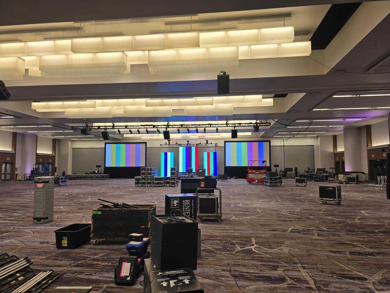 The ballroom set for doors, screens on standby, cases staged at the back