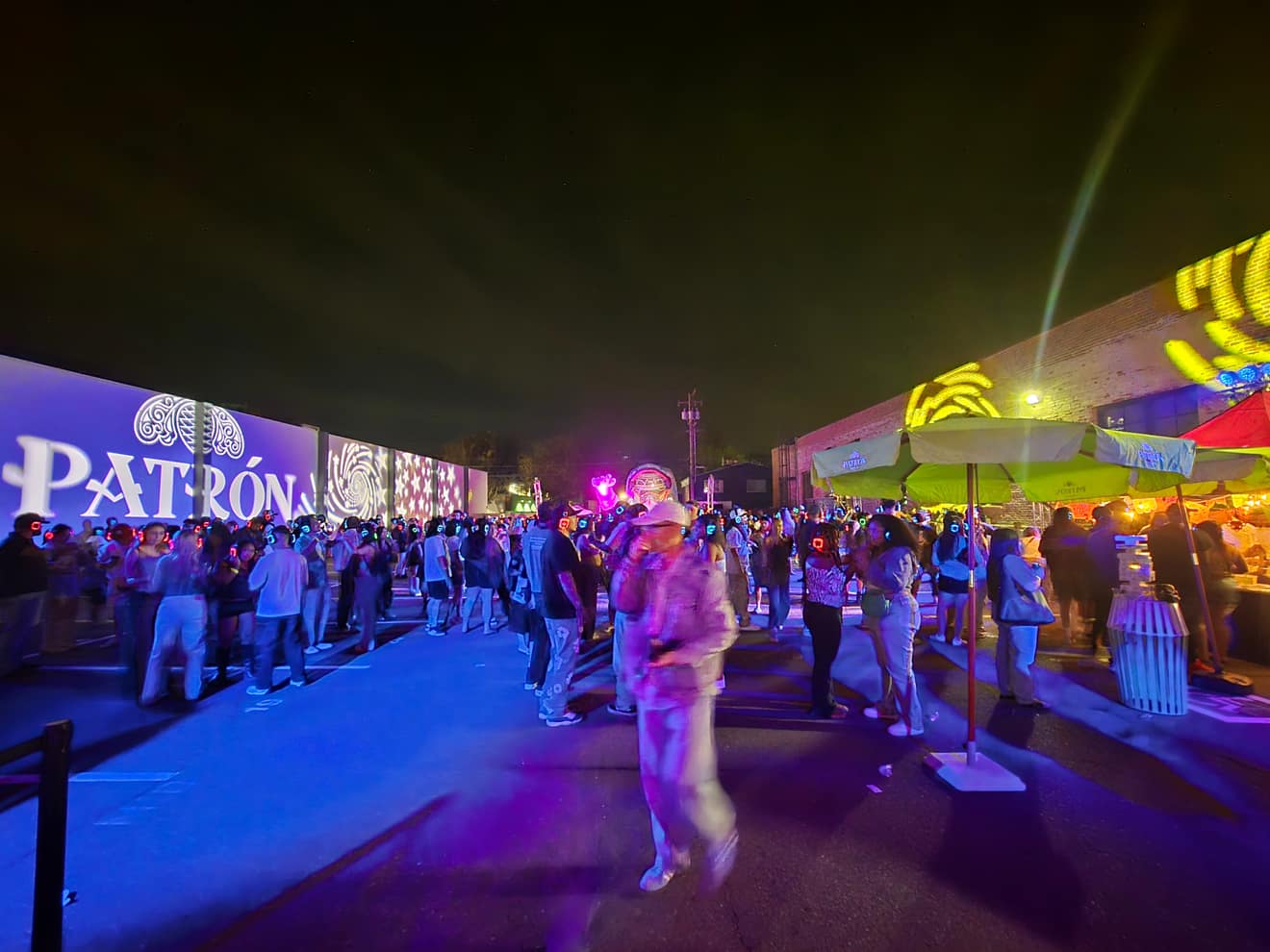 Night Market street scene with string lights and sponsor signage