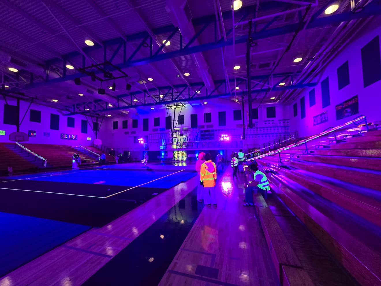 The blacklight floor pattern from a second angle, gym walls glowing purple