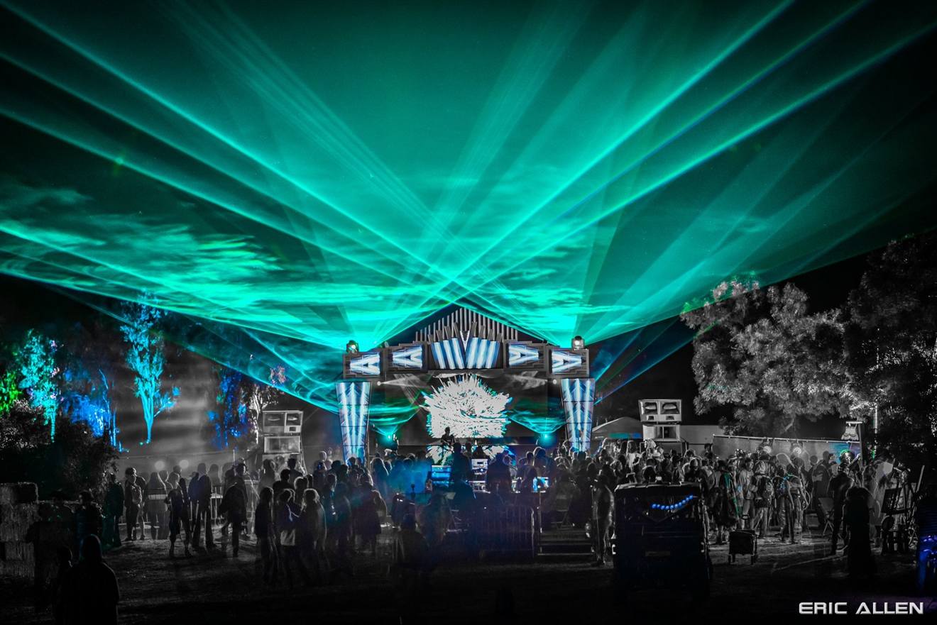 Aqua laser sheets over an outdoor festival stage at night